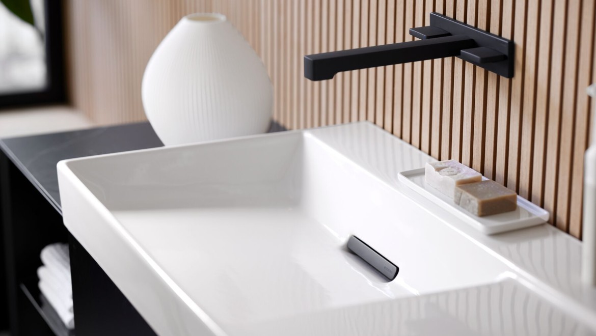 Zona lavabo con rubinetti, mobili da bagno e accessori nel colore nero.