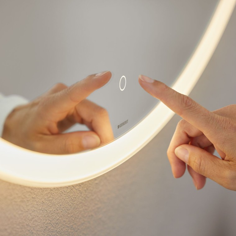 Hand bedient Touchsensor am Spiegel Geberit Option Round (© Geberit) Hand bedient Touchsensor am Spiegel Geberit Option Round (© Geberit)