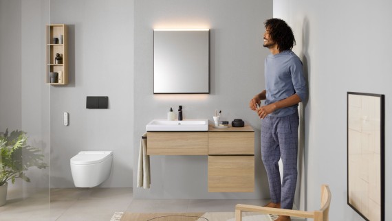 Uomo in un bagno con Geberit AquaClean Sela