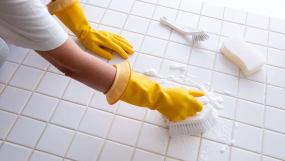 Donna che strofina il pavimento del bagno