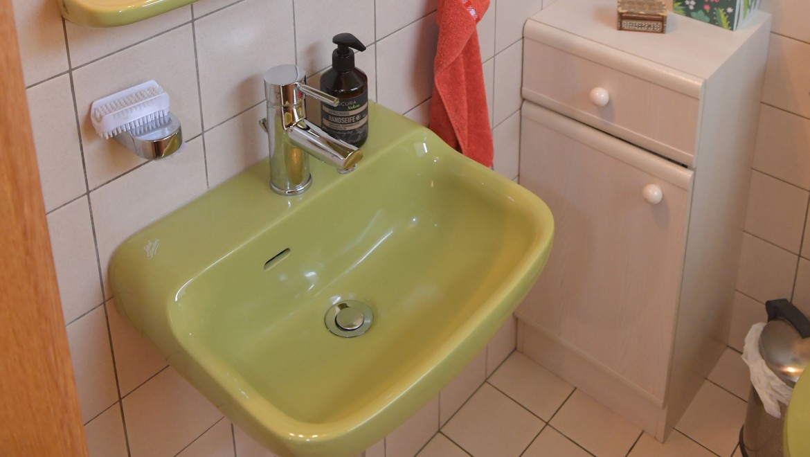 Il bagno degli ospiti con un piccolo armadietto e un lavabo