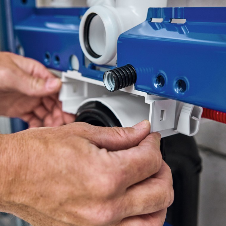 Die Sanitärfachperson installiert das Installationselement für WC und montiert das Gehäuse der Geberit Power & Connect Box vor Die Sanitärfachperson installiert das Installationselement für WC und montiert das Gehäuse der Geberit Power & Connect Box vor