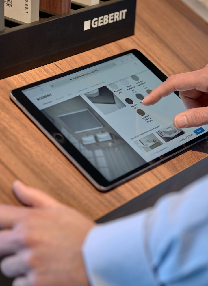 Un homme avec une tablette sélectionne des produits dans un configurateur