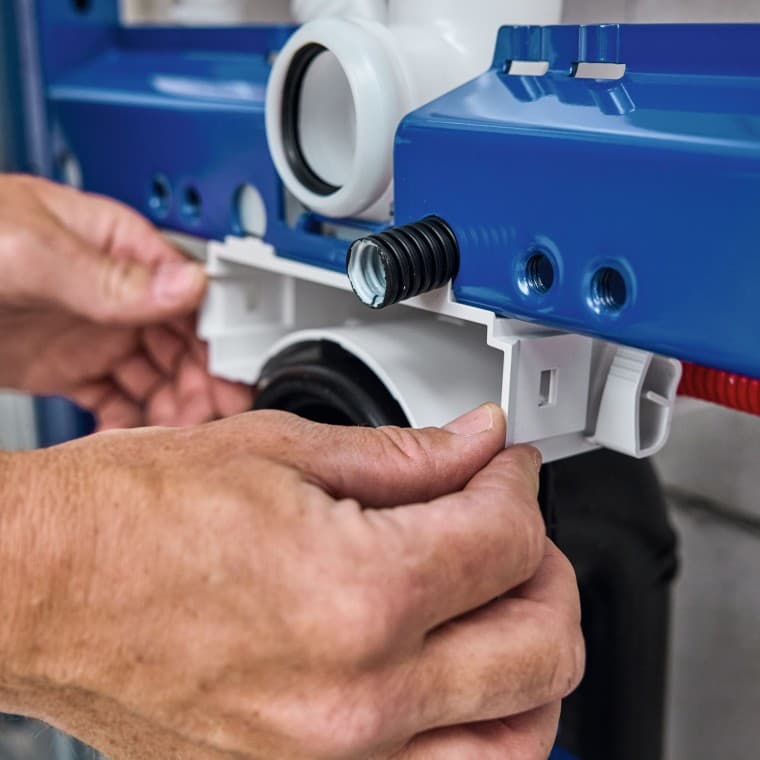 Die Sanitärfachperson installiert das Installationselement für WC und montiert das Gehäuse der Geberit Power & Connect Box vor Die Sanitärfachperson installiert das Installationselement für WC und montiert das Gehäuse der Geberit Power & Connect Box vor